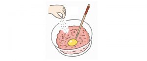 肉だねに卵を割り入れ黄身に菜箸で穴をあける