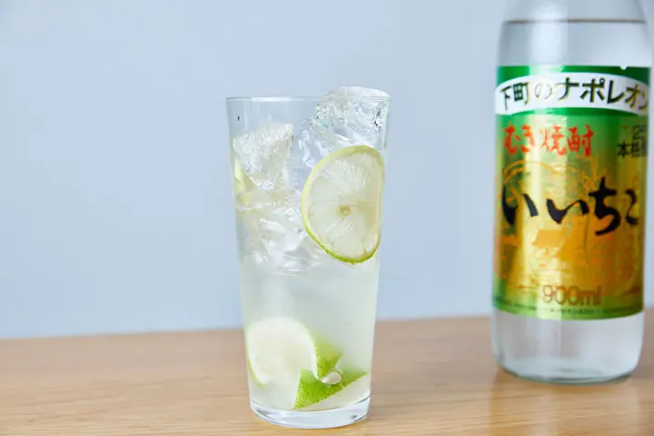 飾り用のレモンスライス（2mmくらいの厚さのものを2枚）をグラスの内側に貼り付け、グラス一杯に氷を入れます。
