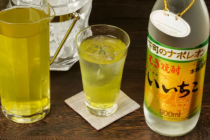 グラスに入った緑茶ハイと、いいちこボトルと割り材の緑茶、アイスペールに入った氷