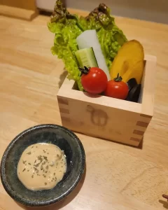 海鮮がウリの居酒屋でもベジファーストなお通しが。升に入った生野菜に自家製マヨネーズソースが添えられた色鮮やかな一品