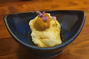こちらの居酒屋のお通しはウニをのせた自家製のごま豆腐。穂紫蘇（ほじそ）を散らし、盛り付けも美しくこだわっています