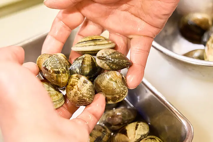 あさりをそっと持ち上げる様子