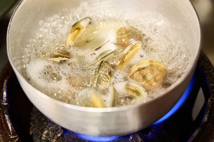 あさりと調味料を鍋に入れ、強めの中火で加熱する様子