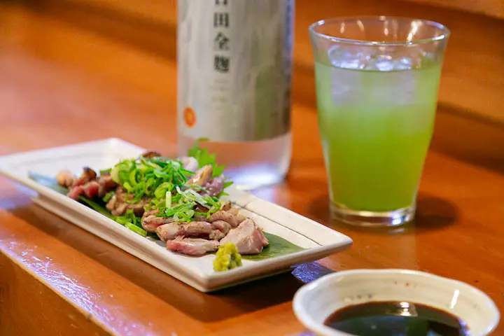 「たこ万本店」のさつま地鶏のたたきと「いいちこ日田全麹」のお茶割り（いい茶こ）